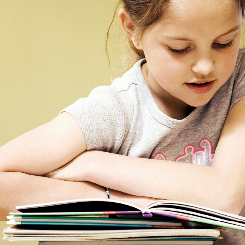 Young girl reading open book