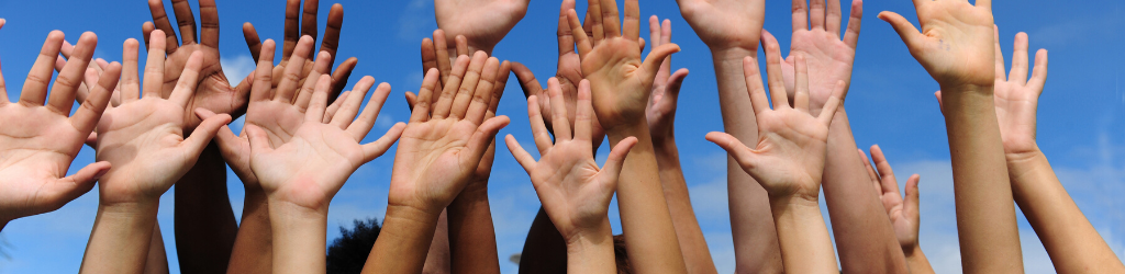 many hands raised up in the sky
