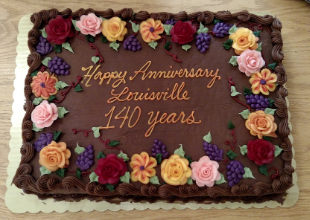 Cake decorated with roses and words "Happy anniversary, Louisville 140 years"