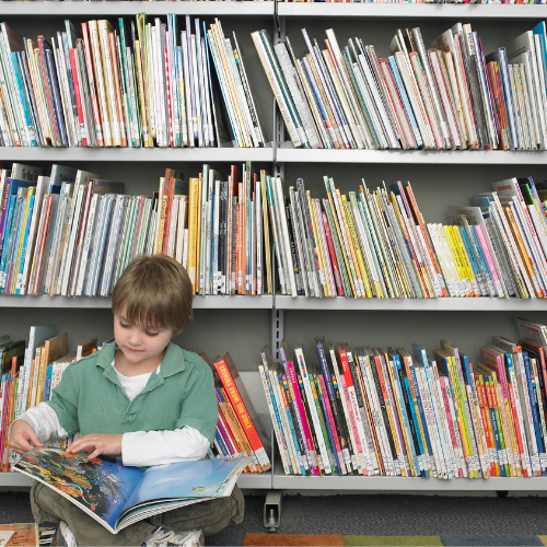Child reading in front of book shelves