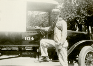 a man in a uniform stands next to a delivery truck 