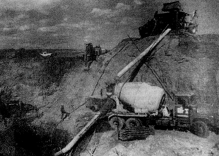 image of a cement mixer next to a large dump
