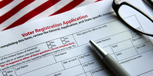 Voter Registration Application with pen and glasses and American flag