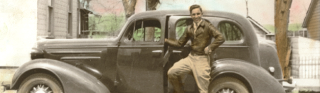 Anthony Colacci in a leather bomber jacket standing by a vintage car