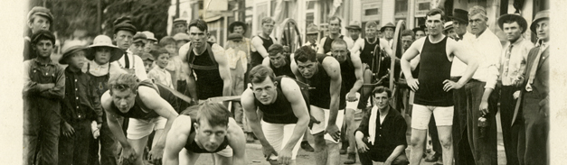 black and white photo of men on Louisville's hose team posing with a hose cart